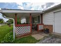 Inviting covered front porch with lattice trim, seating, brick supports, a window, and a concrete walkway at 2520 Tesh Dr, Indianapolis, IN 46203
