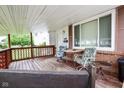 Close-up of a covered front porch with outdoor seating,lattice trim, brick supports, and address number 2520 at 2520 Tesh Dr, Indianapolis, IN 46203