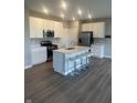 Modern kitchen featuring white cabinets, stainless steel appliances, a center island, and barstool seating at 269 Switchgrass Ln, New Whiteland, IN 46184