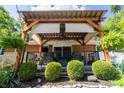 Inviting back deck featuring a pergola, outdoor seating, and lush landscaping at 37 E Waterbury Rd, Indianapolis, IN 46227