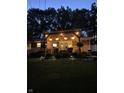 Outdoor deck area with string lights and lush landscaping in the backyard at night at 37 E Waterbury Rd, Indianapolis, IN 46227