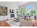 Bright living room featuring soaring ceilings, large windows, fireplace, and hardwood floors at 3711 Pete Dye Blvd, Carmel, IN 46033