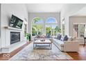 Bright living room featuring soaring ceilings, large windows, fireplace, and hardwood floors at 3711 Pete Dye Blvd, Carmel, IN 46033