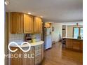 Spacious kitchen with wood floors, light wood cabinetry, and a center island at 4680 Cartersburg Rd, Plainfield, IN 46168