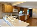 Traditional kitchen featuring light wood cabinets, a microwave, a range, and tile backsplash at 4680 Cartersburg Rd, Plainfield, IN 46168