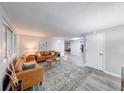 Bright, open living room featuring a comfortable leather sofa, area rug, and a view to dining and kitchen at 5512 Lunsford Dr, Indianapolis, IN 46237