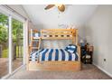 Bright bedroom with bunk beds, carpet floors, and sliding doors to the outdoor scenery at 6300 Grouse Dr, Nineveh, IN 46164
