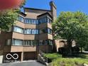Condo building with brick facade, multiple windows, and garage access at 8577 One W Dr # 301, Indianapolis, IN 46260
