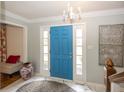 Bright entryway featuring a striking blue front door, marble flooring, and elegant chandelier at 12602 Lockerbie Cir, Carmel, IN 46033