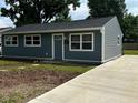 Home exterior featuring gray siding, a new concrete driveway, and manicured yard at 2907 Baltimore Ave, Indianapolis, IN 46218