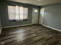 Living room showcasing wood-look flooring, gray walls and a window for natural light at 2907 Baltimore Ave, Indianapolis, IN 46218