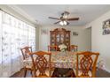 Bright dining room featuring hardwood floors, a ceiling fan, and a view of the front yard at 3624 Newberry Rd, Plainfield, IN 46168