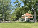 Two-story home boasts a new roof and lush green lawn with mature trees at 4106 N Sherman Dr, Indianapolis, IN 46226