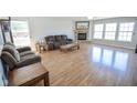 Open living room boasts hardwood floors, stone fireplace, and large windows at 5652 Apple Branch Way, Indianapolis, IN 46237