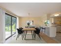 Dining room with large windows and sliding glass doors to back, and view into the kitchen at 6623 Lakeknoll Dr, Indianapolis, IN 46220