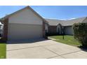 Charming home with a two-car garage, neat landscaping and concrete driveway on a sunny day at 7259 Registry Dr, Indianapolis, IN 46217