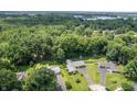 An aerial view of a property featuring surrounding trees and a glimpse of a nearby lake at 7780 Cree Trl, Indianapolis, IN 46250