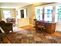 Inviting living room with hardwood floors, a large window, and an elegant writing desk at 7780 Cree Trl, Indianapolis, IN 46250