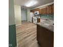 Functional kitchen with white appliances, wood cabinets, and laminate countertops and floors at 8092 Crystal Ct, Avon, IN 46123