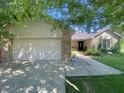 Exterior of home with attached garage, brick accents, and landscaped front yard at 8829 Tracy Dr, Clayton, IN 46118