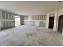 Spacious living room with drywall installed, featuring large windows and sliding glass doors to the outside at 9417 Crimson Cir, Lapel, IN 46051