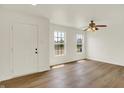 Bright living room with wood floors, a ceiling fan and natural light from two windows at 10658 Pavilion Dr, Indianapolis, IN 46259