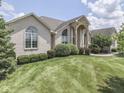 The house is surrounded by lush green landscaping, and features a large arched window above the front door, adding to its appeal at 3270 Cherokee Cir, Bargersville, IN 46106