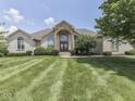 An inviting front exterior of a beautiful house boasts a well-manicured lawn and elegant architectural details at 3270 Cherokee Cir, Bargersville, IN 46106