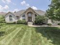 An inviting front exterior of a beautiful house boasts a well-manicured lawn and elegant architectural details at 3270 Cherokee Cir, Bargersville, IN 46106