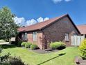 Brick home featuring landscaped yard, mulch beds, and a well maintained lawn at 3400 W Riggin Rd, Muncie, IN 47304