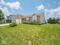 Lovely brick home with an attached garage, complemented by a well-kept lawn and colorful flowerbeds at 5548 Glen Canyon Dr, Indianapolis, IN 46237