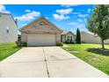 Lovely one-story home featuring a spacious driveway, attached garage, and manicured landscaping at 6383 Enclave Blvd, Greenwood, IN 46143