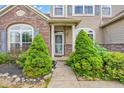 Inviting front entrance featuring lush landscaping, stone pathway, and an arched window at 793 Penny Ln, Pittsboro, IN 46167