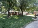 Well-maintained brick ranch home nestled among mature trees with a lush green lawn at 9783 Lee Ct, Columbus, IN 47203