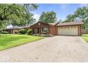 A brick home featuring a wide driveway and an attached two-car garage, set back from the street at 3331 Loral Dr, Anderson, IN 46013