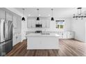 Bright kitchen featuring an island with stainless appliances, granite countertops, modern lighting, and sleek hardwood flooring at 3980 Canning St, Danville, IN 46122