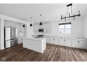 Bright kitchen featuring an island with stainless appliances, granite countertops, modern lighting, and sleek hardwood flooring at 3980 Canning St, Danville, IN 46122