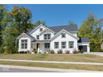 Beautiful two-story white home with dark trim, professional landscaping, and black shingle roof at 8722 Rockwood Ln, Indianapolis, IN 46259