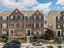 Traditional brick townhome with black shutters, a manicured front yard, and convenient parking at 958 Rosalind Pl, Carmel, IN 46032