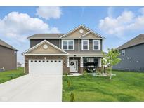 Charming two-story home featuring a well-manicured lawn and attached two-car garage at 211 Walker Dr, Whiteland, IN 46184