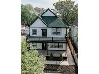 Charming two-story house featuring a balcony, black trim, a new roof and lovely landscaping at 221 Eastern Ave, Indianapolis, IN 46201
