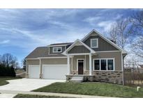 Two-story craftsman style home with attached two-car garage, stone accents, and a welcoming front porch at 5286 Stonehaven Ln, Columbus, IN 47201