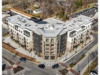 Stunning aerial view of a modern apartment building with a unique architectural design and ample parking at 1155 S Rangeline Rd # 507, Carmel, IN 46032