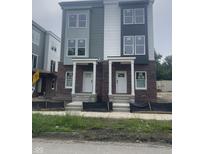Newly constructed townhomes displaying modern brick and siding, complemented by white trim and inviting front porches at 249 N Temple Ave, Indianapolis, IN 46201
