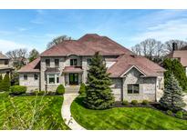 Stately stone home showcasing a manicured lawn and classic architectural design with a welcoming walkway at 11492 Hanbury Manor Blvd, Noblesville, IN 46060