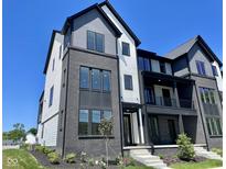 Modern townhome with a striking black brick facade, light siding, and contemporary architectural details at 379 S Cherry St, Westfield, IN 46074