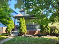 Two-story green house with a front porch and landscaping at 2133 N Park Ave, Indianapolis, IN 46202