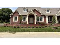 Charming brick home with dormer windows, cream trim, and manicured front yard at 7936 Beaumont Green Pl, Indianapolis, IN 46250