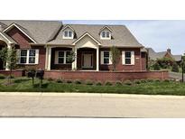 Charming brick home featuring symmetrical windows, dormers, and a quaint front porch with white columns at 7942 Beaumont Green Pl, Indianapolis, IN 46250