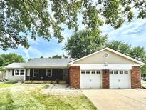 Ranch-style home with brick facade, two-car garage, and landscaped yard at 1625 Michele, Greenwood, IN 46142